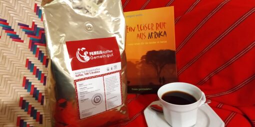 Geschenke unter 40 Euro Buch einer deutschen Lehrerin Kenia Tasse Kaffee goldenes Kaffeepäckchen Hintergrund Decke rot mit Streifen Bastkorb gemustert
